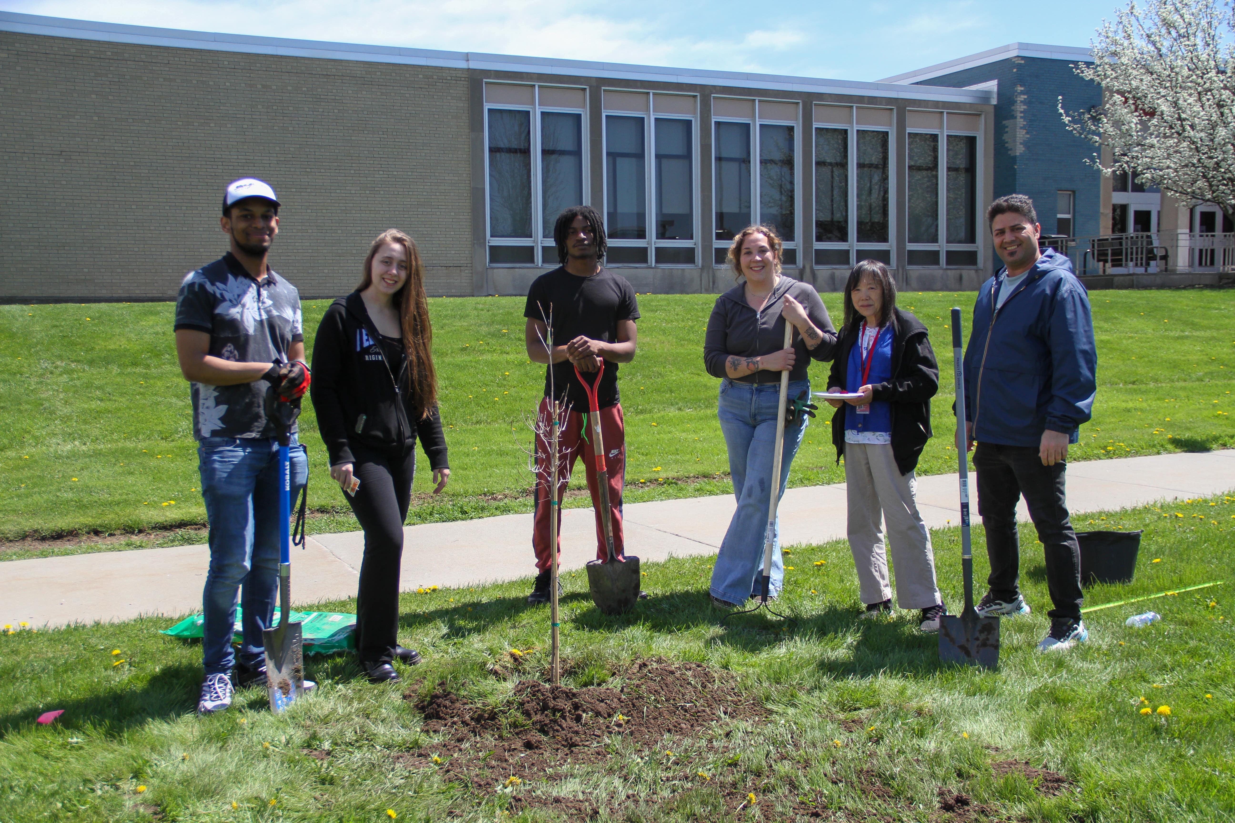 6 students standing infront of a tree they freshly planted at SUNY Erie's North Campus