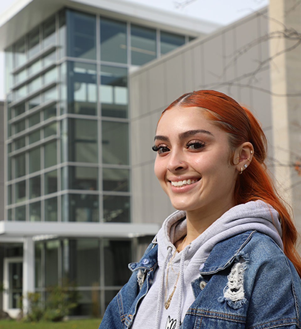 Student smiling in front of ECC building