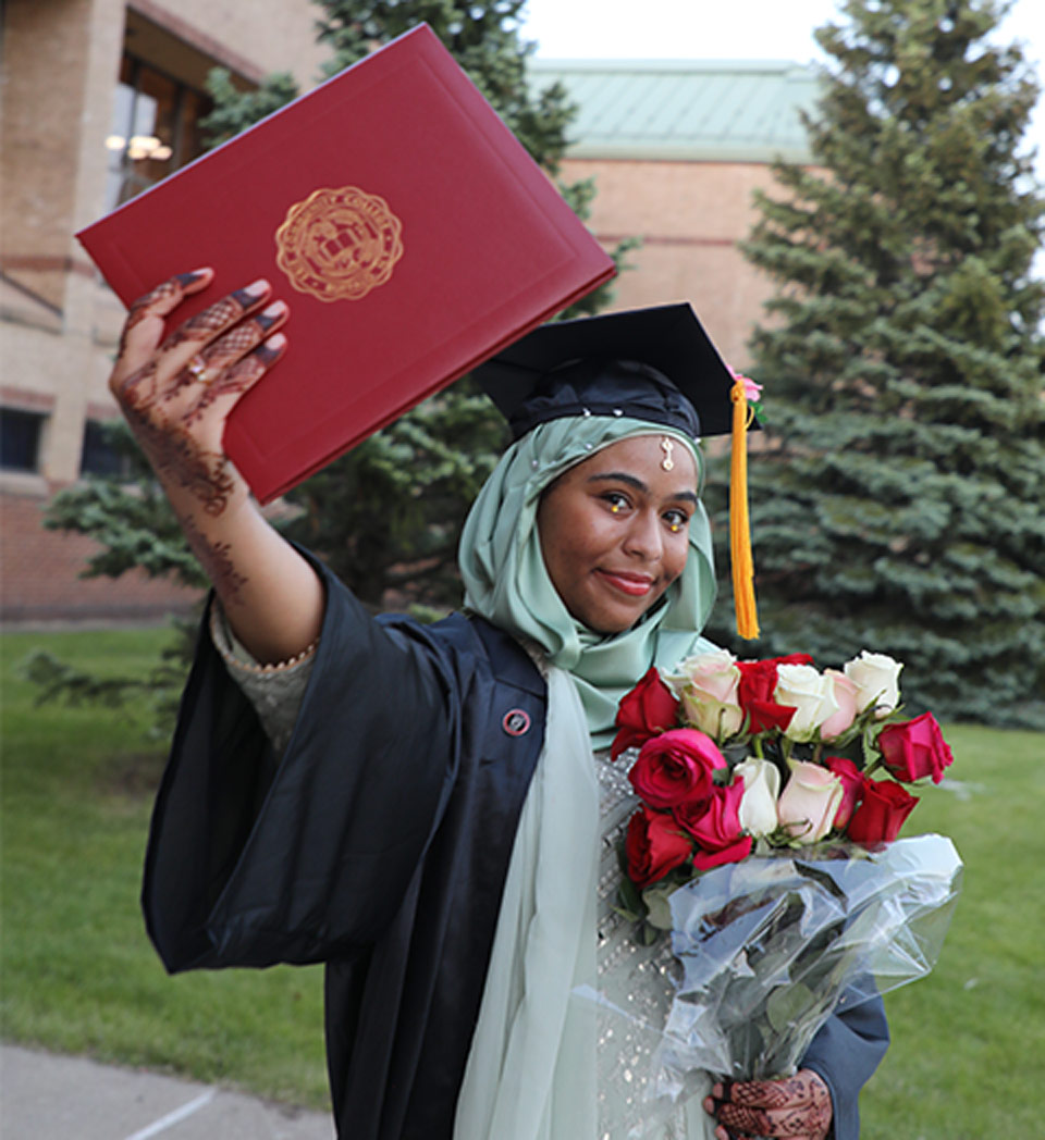 Student holding diploma and flowers